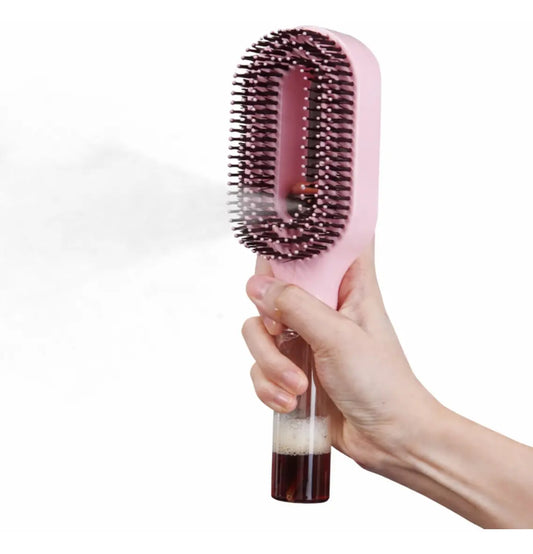 Hand holding the Luvandra misting brush while it sprays a fine water mist